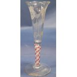 An 18th century trumpet shaped wine glass with etched rosebud and butterfly detail, set on a