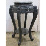 A Chinese ebonised jardiniere stand of circular form with carved and pierced foliate and further