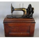 A vintage Singer sewing machine and its mahogany case