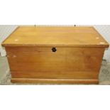 A stripped pine blanket box with hinged lid and drop side iron work carrying handles,