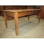 An old stripped pine farmhouse kitchen table with rectangular three plank top raised on square