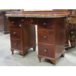 A mahogany kneehole dressing table with kidney shaped top over an arrangement of seven frieze