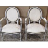 A pair of small French salon chairs with painted and moulded frames and upholstered seats, backs and