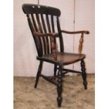 A Windsor dark stained elm beechwood lathe back elbow chair with saddle shaped seat raised on turned