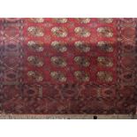 A Belgian wool carpet in the Bokhara manner upon a red ground, 290 x 190cm