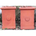 A pair of contemporary terracotta planters of square cut and moulded form, with repeating flowerhead