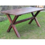 An oak tavern table of usual form, the oak plank top raised on a pair of X shaped pine supports,