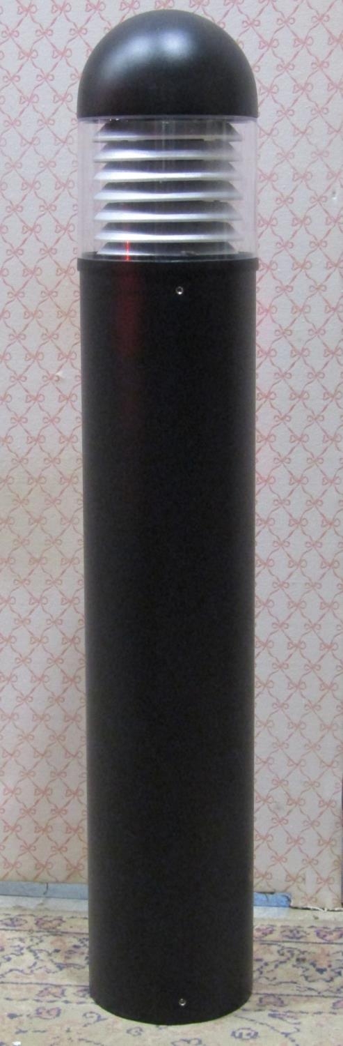 A contemporary exterior bollard shaped lamp