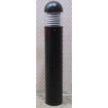 A contemporary exterior bollard shaped lamp