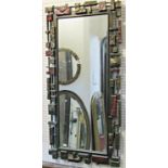 A decorative wall mirror of rectangular form, the painted composite frame in the brutalist manner