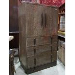 An Art Deco style limed/fumed linen cupboard with fixed stepped and moulded handles and enclosed