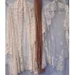 A 19th century lace veil/ shawl of ivory silk with floral borders around simple paisley motifs
