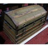 A canvas and wooden bound domed trunk containing hunting prints, a pair of vintage riding boots,
