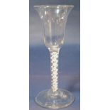 A Georgian wine glass with trumpet shaped bowl and latticino stem, raised on a circular base