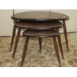 A nest of three Ercol dark stained elm and beechwood "pebble" occasional tables (ring marks and