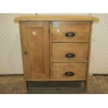 A small rustic stripped pine cabinet enclosed by a rectangular panelled door and three drawers, 88