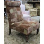 An Edwardian nursing chair with later alternating striped and patches upholstery, scrolled head rest