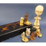 A number of bone and composite oriental figures within a lacquered glove box