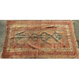Antique Persian rug with block blue medallion central decoration upon a washed red ground, 220 x