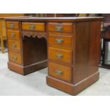 A late Victorian walnut writing desk with inset leather top over an arrangement of nine frieze