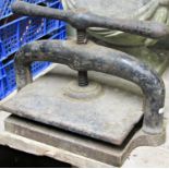 A cast iron book press with central screw thread and club shaped handle 42 cm wide x 25 cm deep x 25