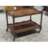 A Victorian mahogany two tier tea trolley of rectangular form raised on turned and fluted supports