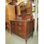 An Edwardian oak dressing chest of two long and two short drawers with raised arched swing mirror