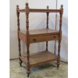 A Victorian stripped oak three tier whatnot with central frieze drawer and turned supports raised on