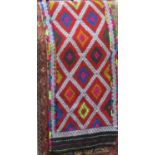 A flat weave Persian style runner with repeating lozenge shaped detail, in a very bright