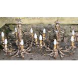 A pair of antiqued six branch chandeliers with scrolled detail by Bella Figura