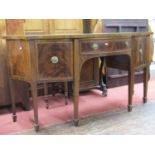 An Edwardian mahogany sideboard with well shaped outline, the central door flanked by two cupboards,