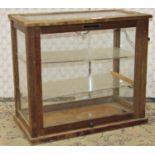 A small wooden framed and glazed counter top display case with applied label Griffin & George Ltd,