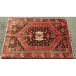 Persian Bakhtiar rug with central dark medallion upon a washed red ground, 190 x 130cm