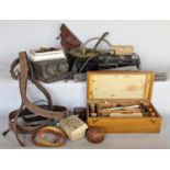 A box containing leather straps and belts, sewing items, a tin money, a paint box, compass and a