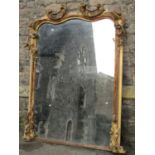 A large 19th century gilt framed overmantle mirror, the arched outline decorated with carved and