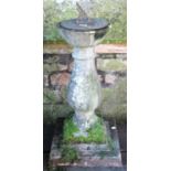 A reclaimed two sectional sundial with square stepped platform base supporting a baluster