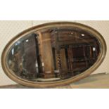 An Edwardian oval wall mirror with bevelled edge plate and moulded frame, 129 cm x 75 cm