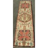 Good quality Heriz runner with three large black and gold medallion decorations upon an ivory