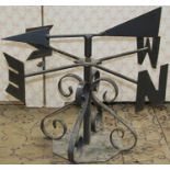 A small iron work weather vane with arrow shaped pointer, scrolled supports and octagonal platform