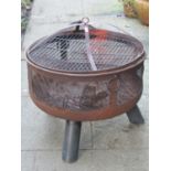 A weathered contemporary firepit of circular form, with mesh panels and splayed supports, 62cm