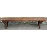 A vintage stained pine low bench with folding supports 182cm long x 25cm wide x 44cm high