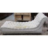 A Victorian style day bed with repeating cream ground floral sprig pattern buttoned upholstered