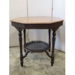An Edwardian walnut occasional table of octagonal form raised on four turned tapered legs united
