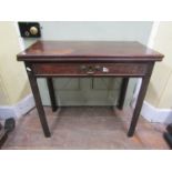 A Georgian mahogany foldover top tea table of rectangular form enclosing a single frieze drawer,