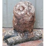 A small reclaimed garden ornament in the form of an owl perched on a branch, 27cm high