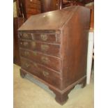 A Georgian oak bureau, the fall flap enclosing a fitted interior of small drawers, pigeon holes