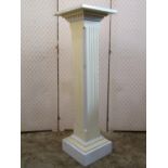 A painted pine pedestal with a square cut chamfered and fluted column, raised on a square stepped