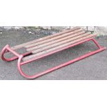 A vintage sledge with red metal frame