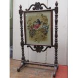 A mid 19th century mahogany framed firescreen, the turned and carved framework with simulated