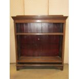 An Edwardian oak freestanding open bookcase with two adjustable shelves and raised on bracket